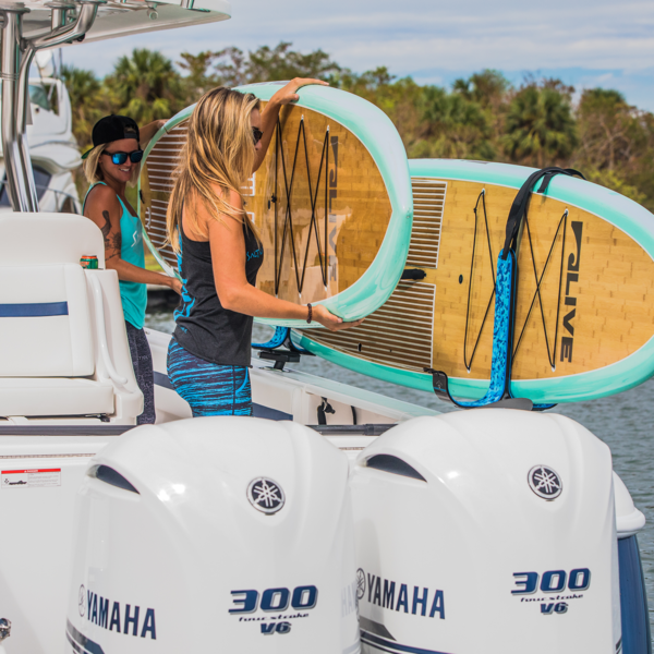 Image of people in a boat with SUPs and SUP racks.